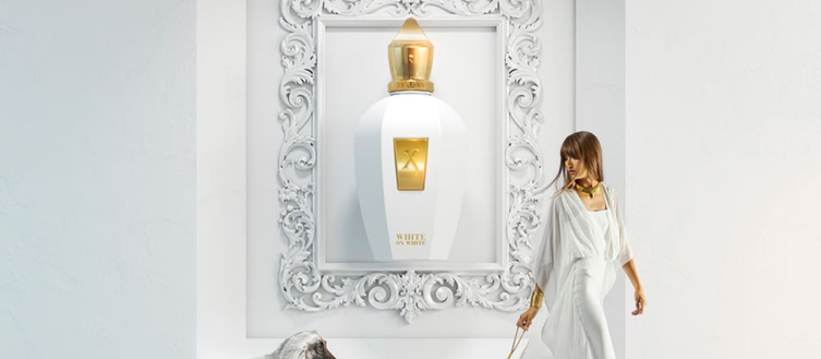 Perfume de nicho Xerjoff V Erba Gold - Con una mujer vestida de blanco.
